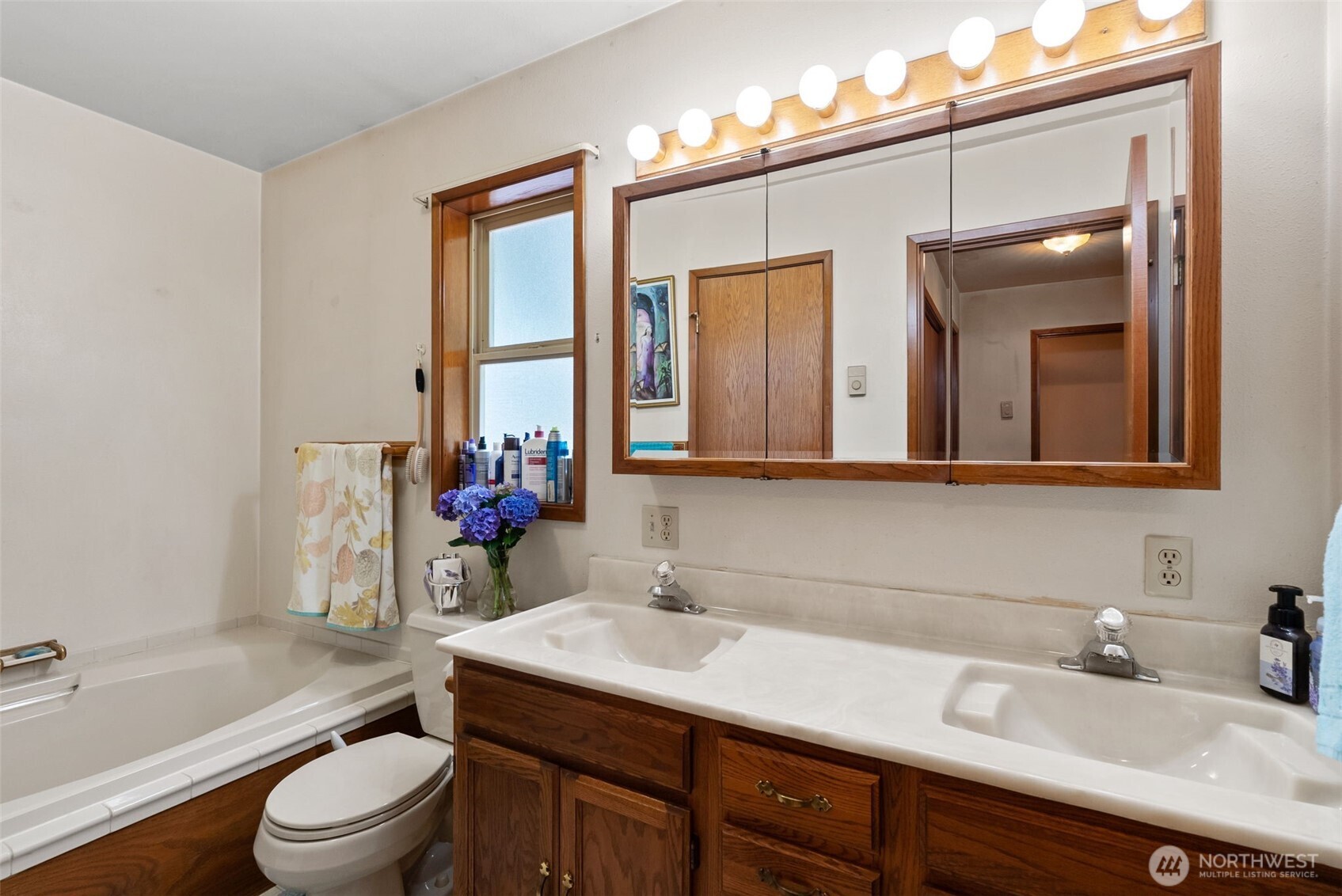 1142 SR 6 Raymond, WA 98577 - Photo 16 of 40 a bathroom with a granite countertop sink toilet a large mirror and a tub