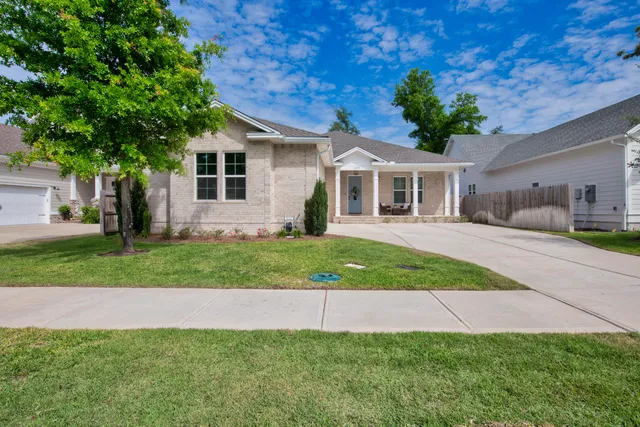 a front view of a house with a garden and plants