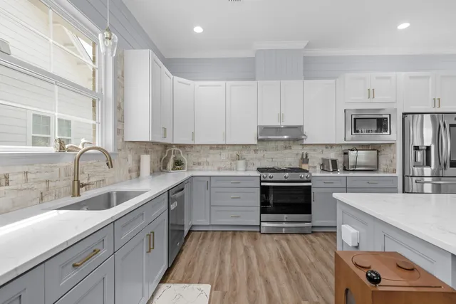 a kitchen with stainless steel appliances a stove sink and cabinets