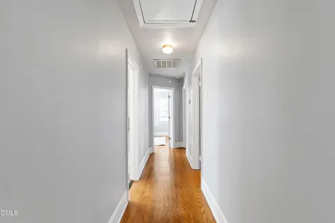 a view of a hallway with wooden floor