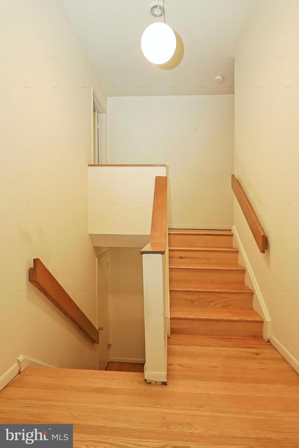1605 Inlet Court Reston, VA 20190 - Photo 23 of 63 Hardwood stairs and a mid-century ceiling light