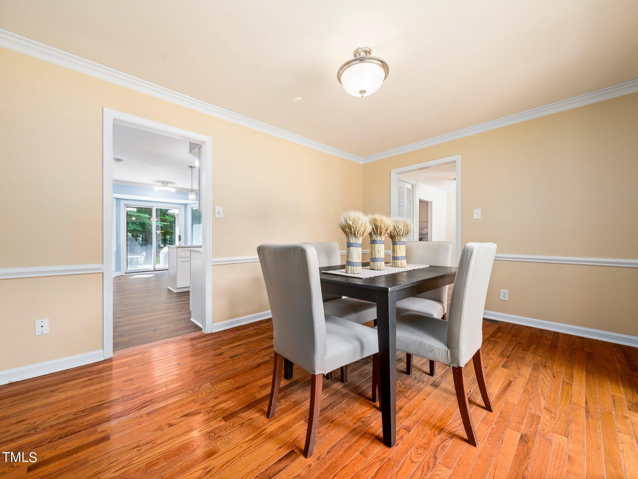 512 Brittany Bay West Raleigh, NC 27614 - Photo 11 of 27 a view of a dining room with furniture and wooden floor