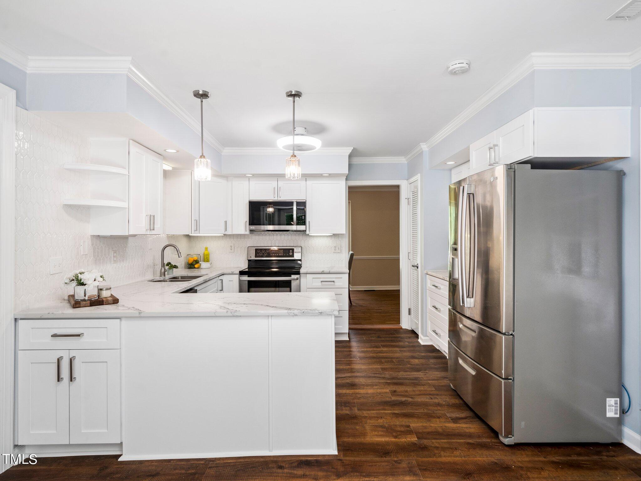 512 Brittany Bay West Raleigh, NC 27614 - Photo 3 of 27 a kitchen with kitchen island white cabinets and stainless steel appliances