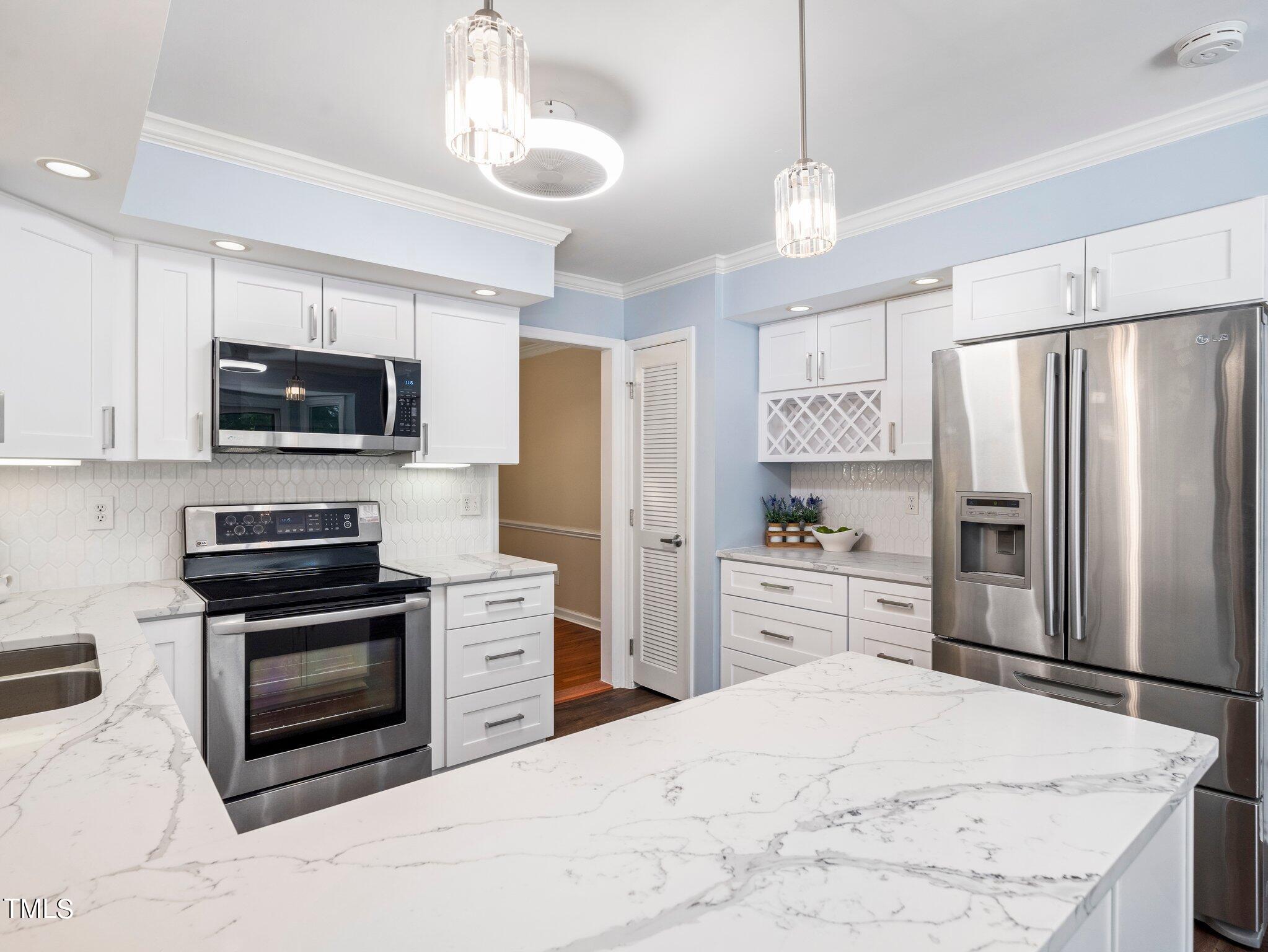 512 Brittany Bay West Raleigh, NC 27614 - Photo 4 of 27 a kitchen with granite countertop a refrigerator stove and microwave