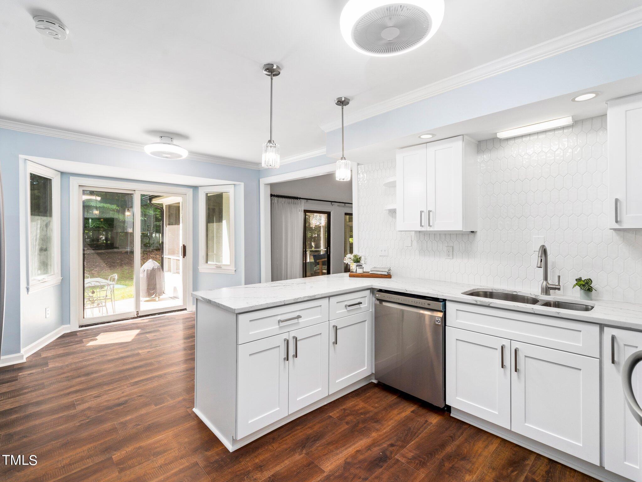 512 Brittany Bay West Raleigh, NC 27614 - Photo 6 of 27 a kitchen with stainless steel appliances granite countertop a sink stove and white cabinets with wooden floor