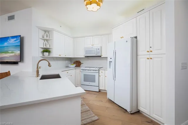 a kitchen with stainless steel appliances white cabinets and a refrigerator