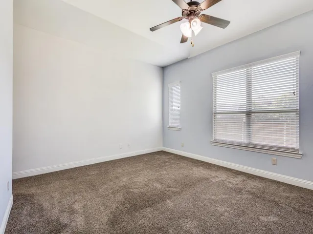 an empty room with fan and windows