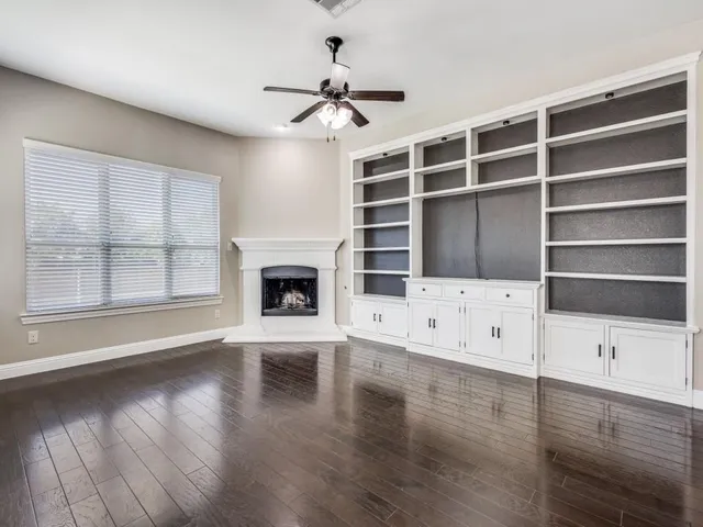 wooden floor in an empty room with a fireplace and wooden floor