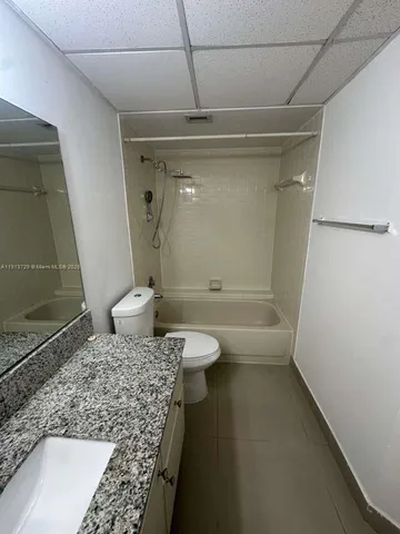 a bathroom with a granite countertop sink a toilet and shower