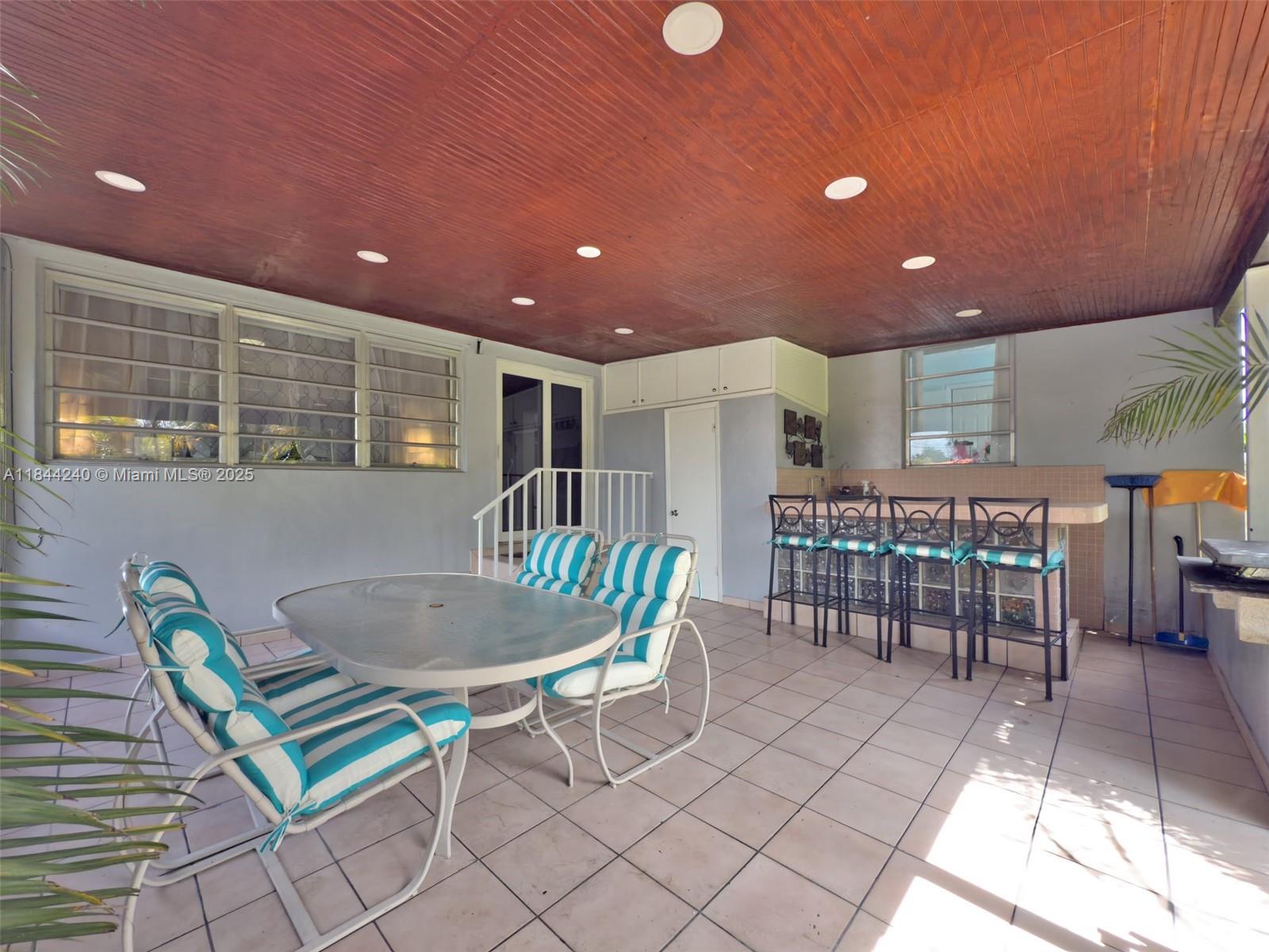 6290 Southwest 37th Street Miami, FL 33155 - Photo 12 of 34 a dining room with furniture and a floor to ceiling window