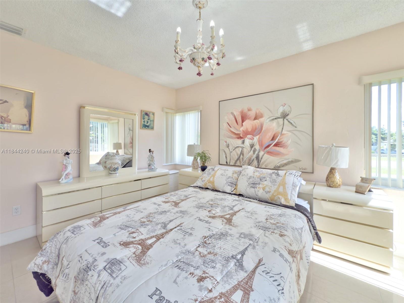 6290 Southwest 37th Street Miami, FL 33155 - Photo 19 of 34 a bedroom with a large bed and a chandelier