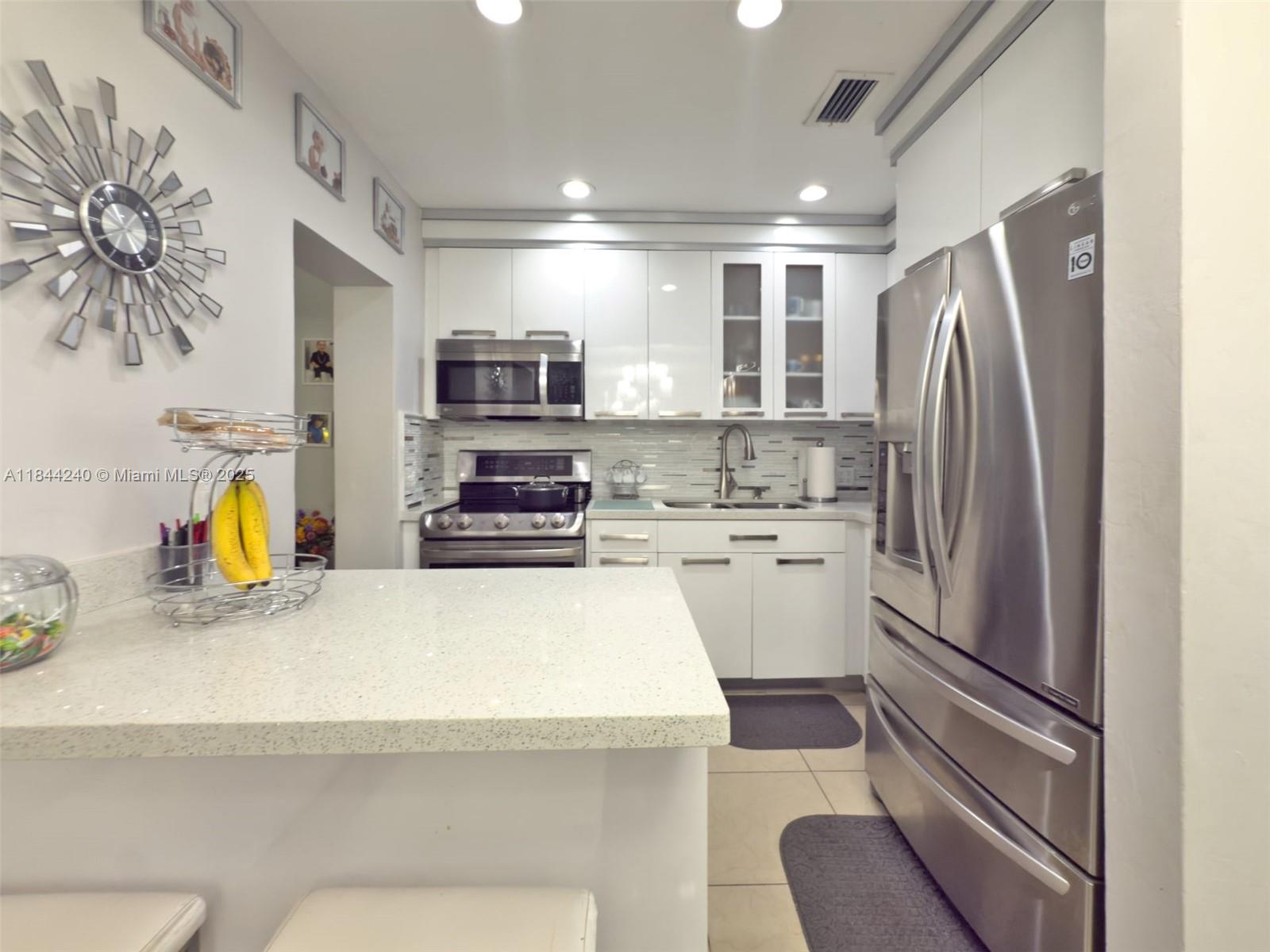 6290 Southwest 37th Street Miami, FL 33155 - Photo 24 of 34 a kitchen with stainless steel appliances a refrigerator sink and stove