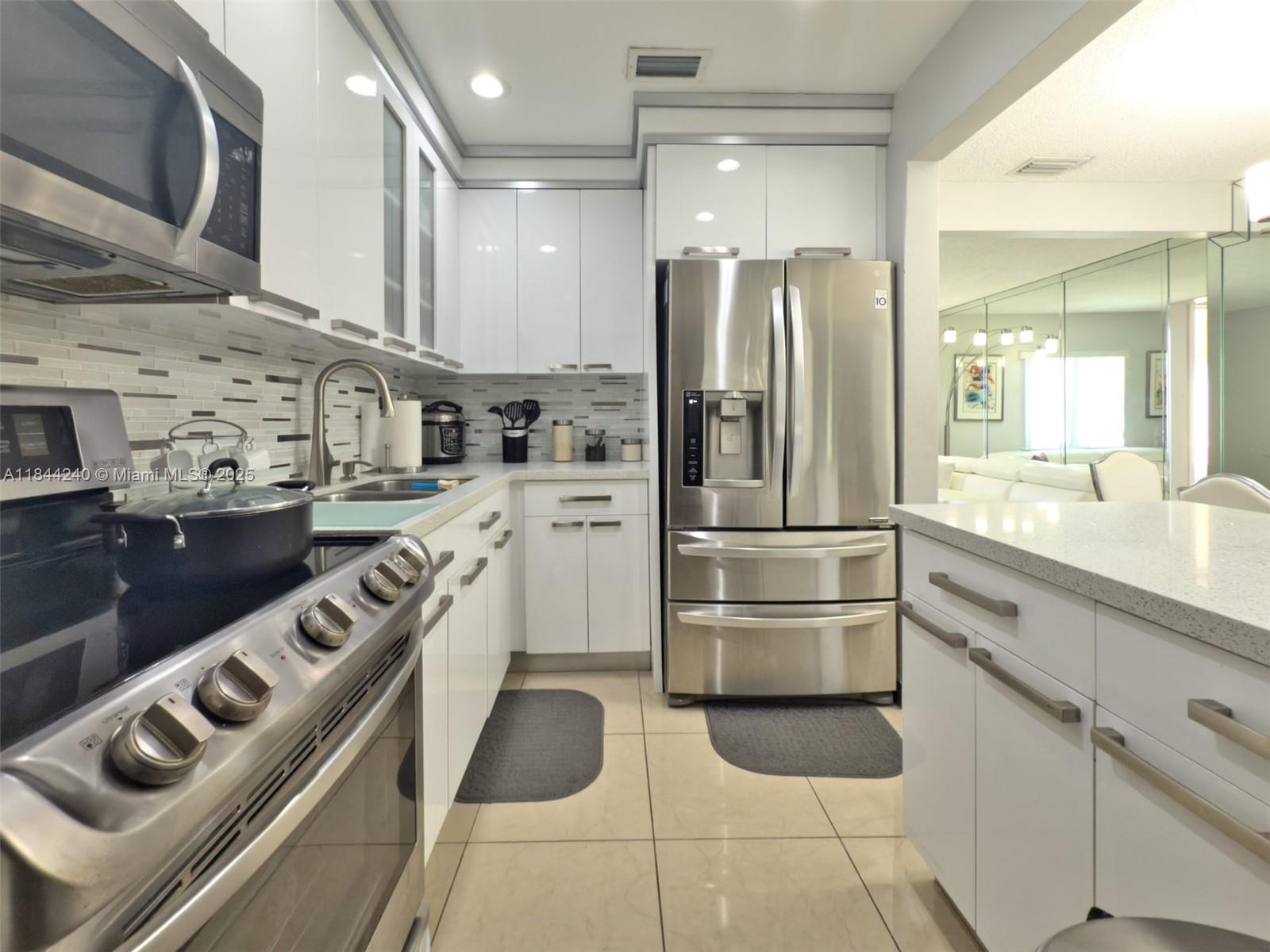 6290 Southwest 37th Street Miami, FL 33155 - Photo 27 of 34 a kitchen with stainless steel appliances granite countertop a refrigerator and a sink