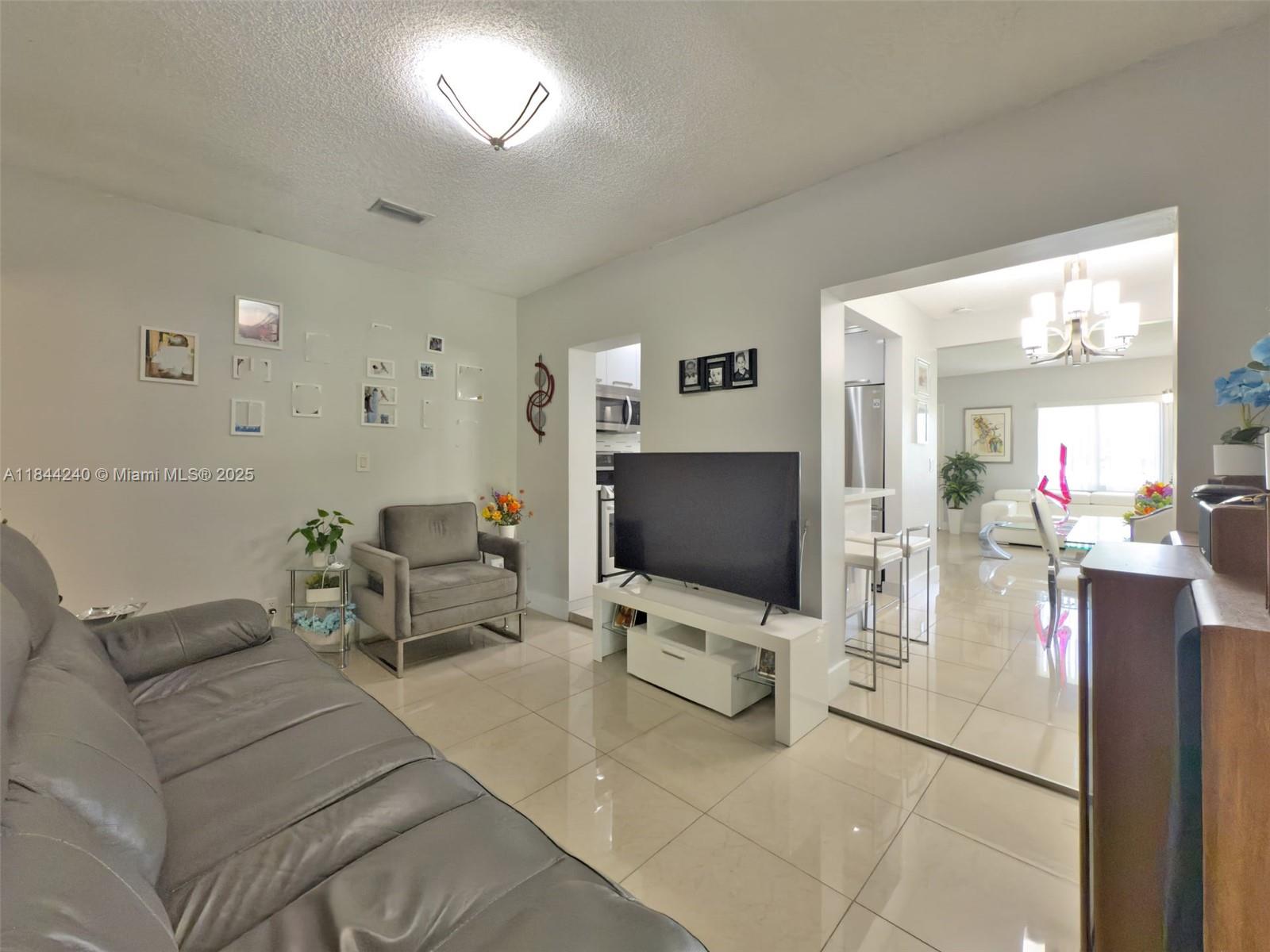 6290 Southwest 37th Street Miami, FL 33155 - Photo 29 of 34 a living room with furniture and a flat screen tv