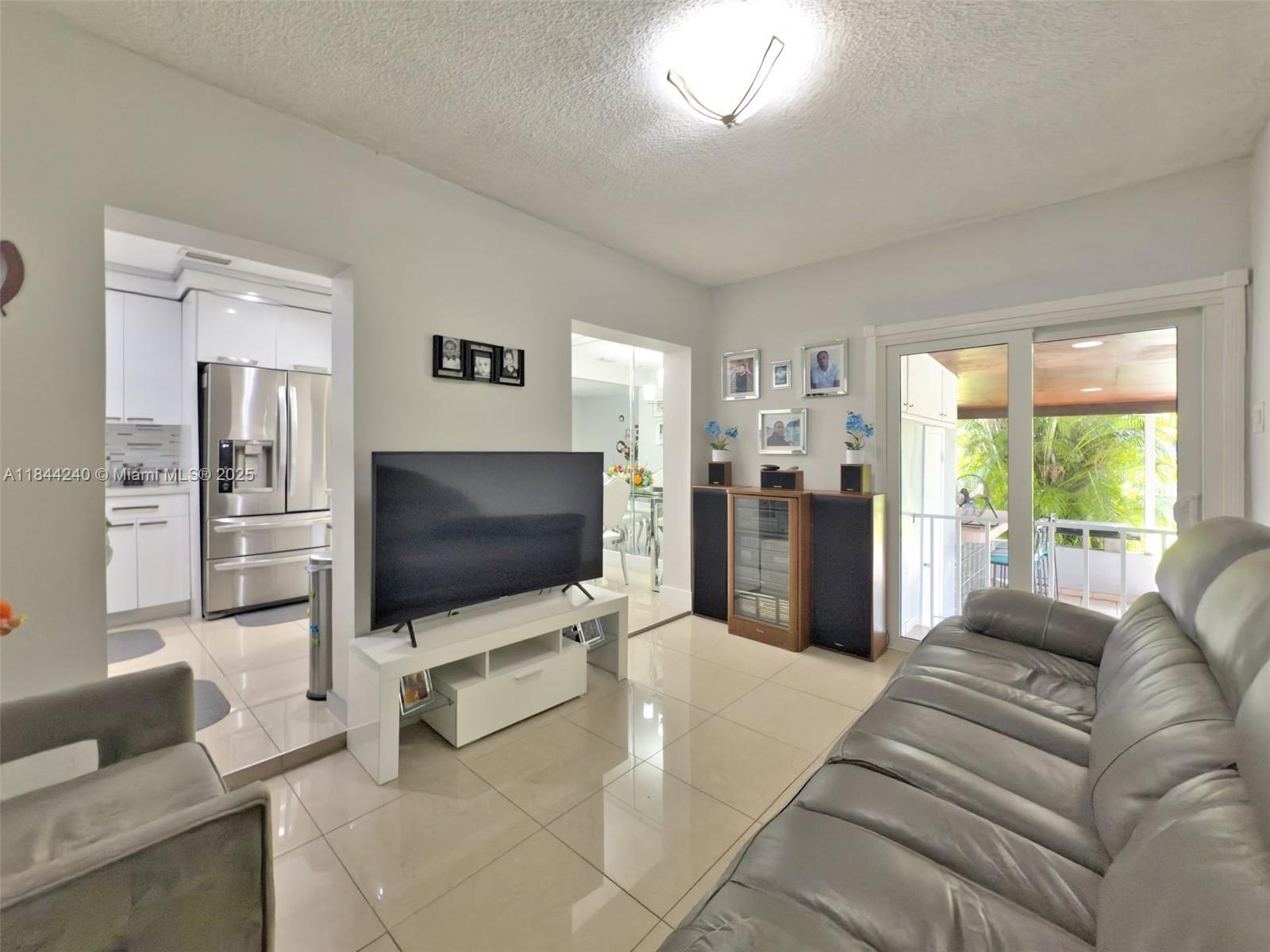 6290 Southwest 37th Street Miami, FL 33155 - Photo 30 of 34 a living room with furniture and a flat screen tv
