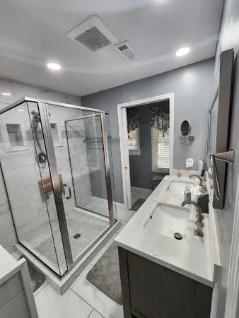 a bathroom with a sink a mirror and a glass door shower