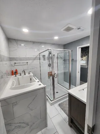 a en suite bathroom with a sink mirror and shower