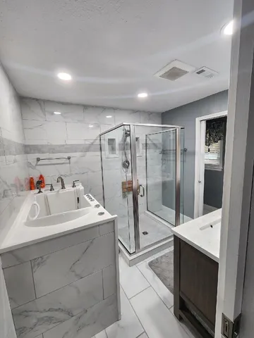 a en suite bathroom with a sink mirror and shower