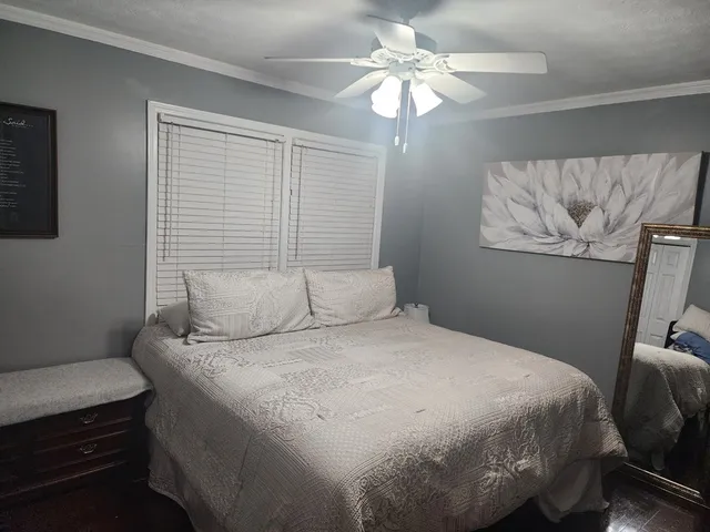 a bedroom with a bed dresser and a window