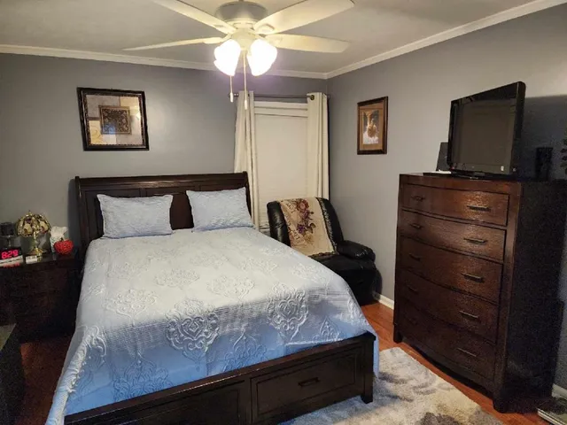 a bedroom with a bed and a flat tv screen on dresser