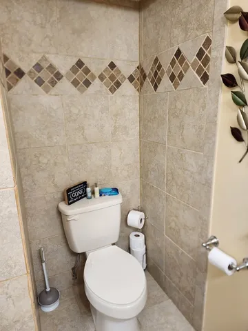 a white toilet sitting next to a bathroom sink and a shower