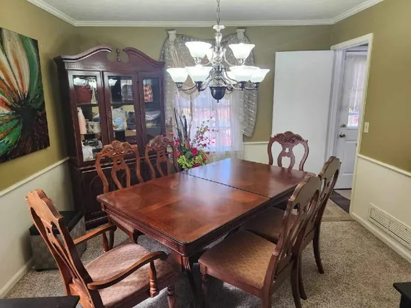 a view of a dining room with furniture and chandelier