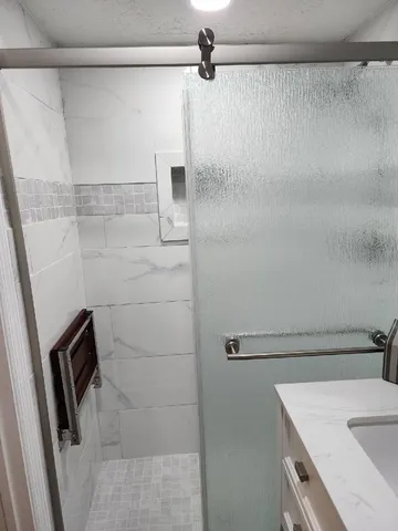 a bathroom with a sink a mirror and shower