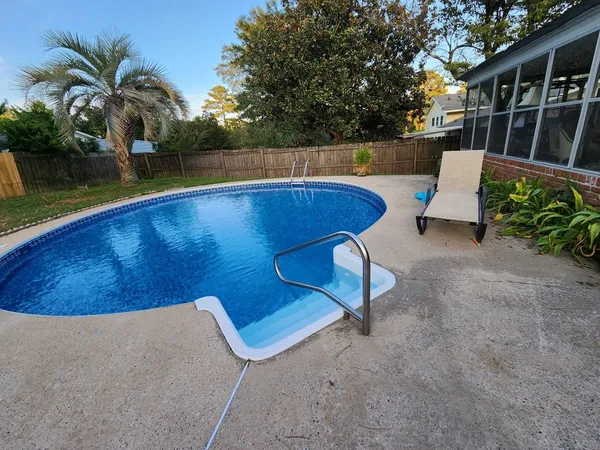 a view of swimming pool with a chair and potted plants
