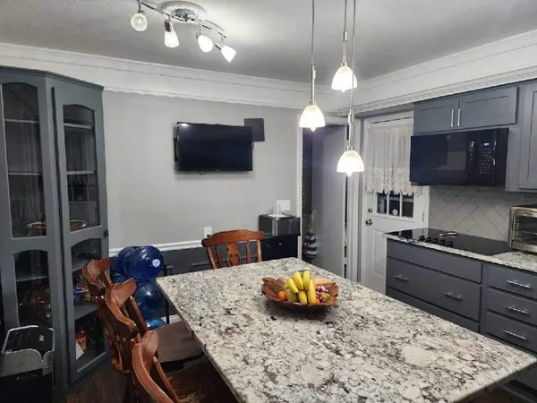 a kitchen with stainless steel appliances wooden floor dining table and chairs