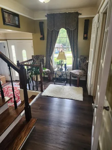 a view of a living room with hardwood floor and a window