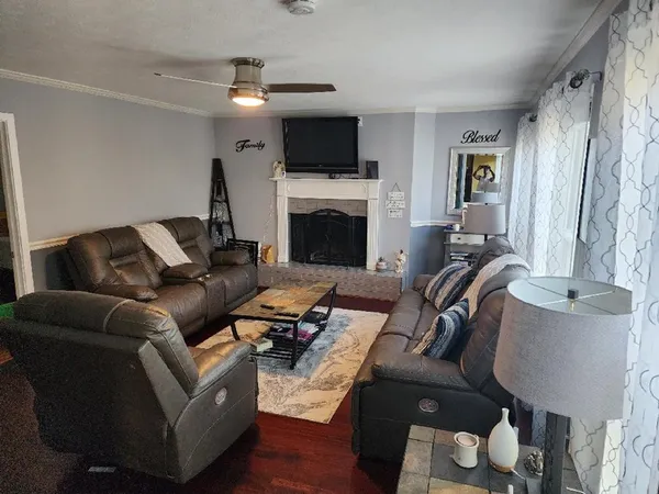 a living room with furniture a flat screen tv and a fireplace