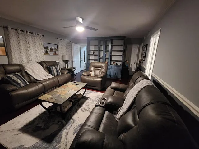 a living room with furniture and a book shelf
