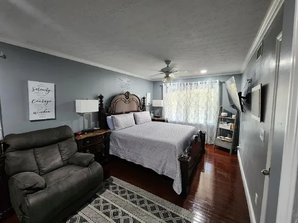 a spacious bedroom with a bed couch and a window
