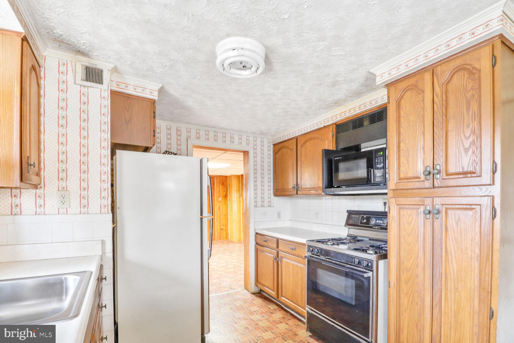 6250 Old Washington Road Elkridge, MD 21075 - Photo 10 of 28 a kitchen with stainless steel appliances granite countertop a refrigerator a stove top oven a sink and dishwasher