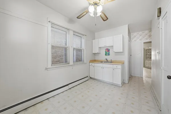 a kitchen with a refrigerator and white cabinets