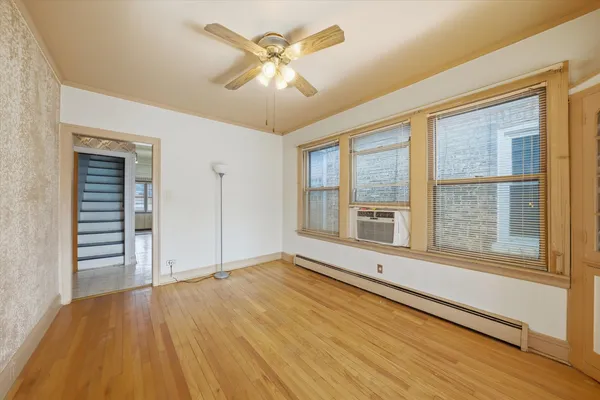 a view of an empty room with a window and wooden floor