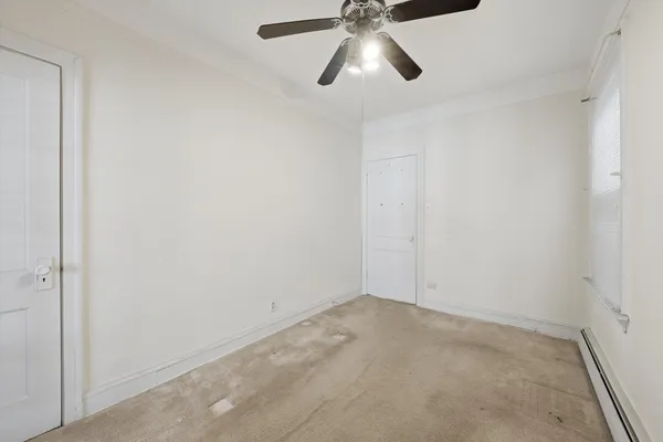 an empty room with a chandelier fan