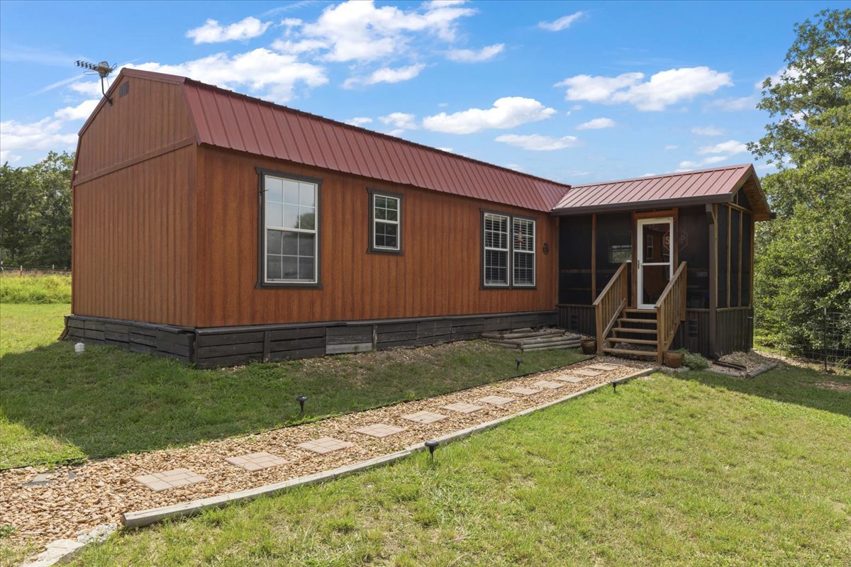 1705 Makinson Road West Point, TX 78963 - Photo 12 of 40 A charming rustic home featuring a bright red metal roof and a welcoming screened porch.