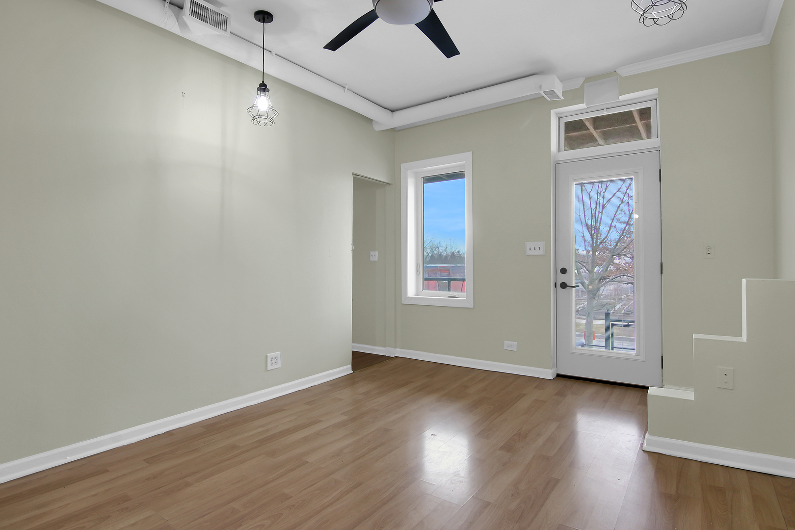 2740 South Troy Street, Unit 1F Chicago, IL 60623 - Photo 5 of 13 an empty room with windows and ceiling fan