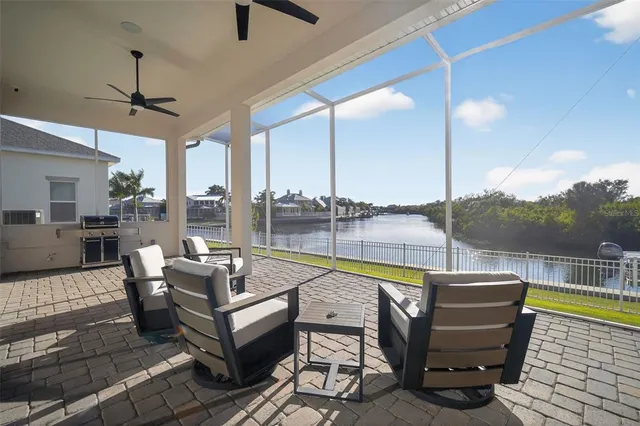 a large white open kitchen with stainless steel appliances granite countertop a stove a refrigerator a oven with a dining table and chairs with wooden floor