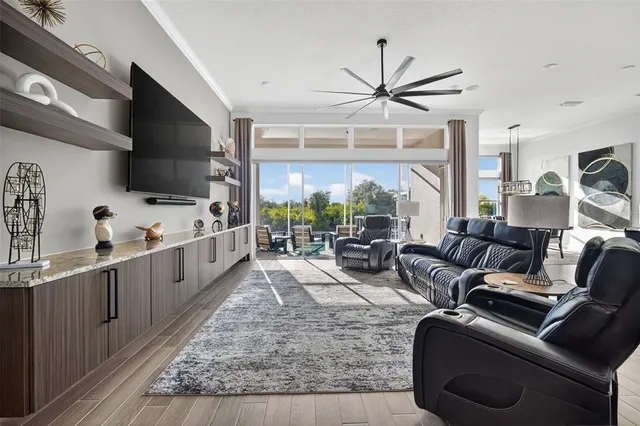 a living room with furniture wooden floor and a kitchen view