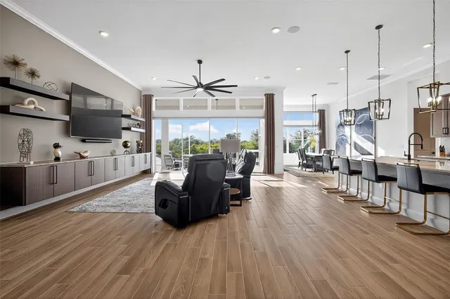 a living room with furniture a flat screen tv and kitchen view