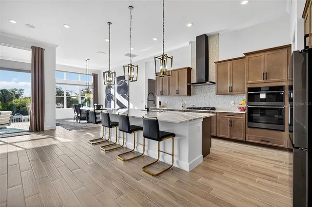 a view of a livingroom with furniture chandelier wooden floor and windows