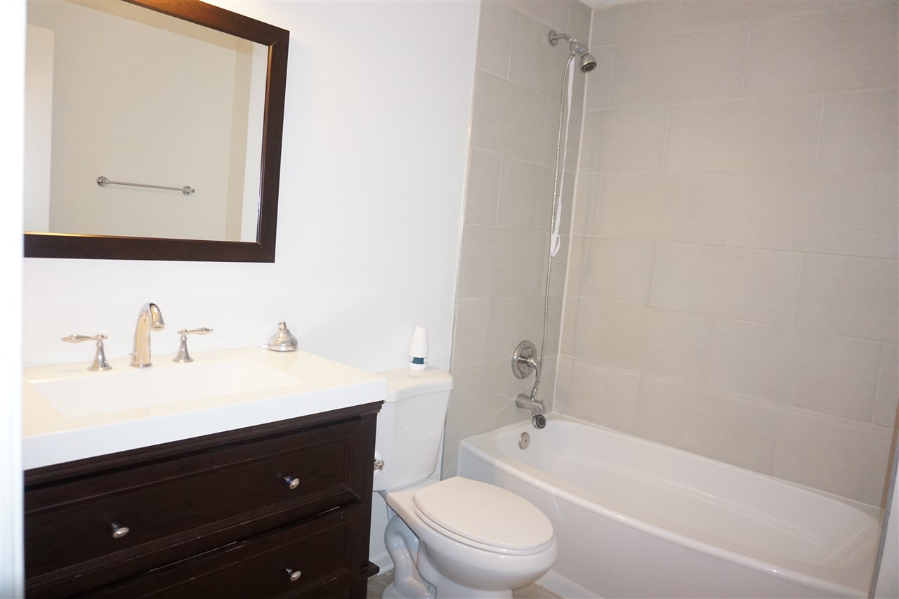 403 Pembroke Road Southwest Poplar Grove, IL 61065 - Photo 14 of 19 a bathroom with a bathtub sink vanity mirror and toilet
