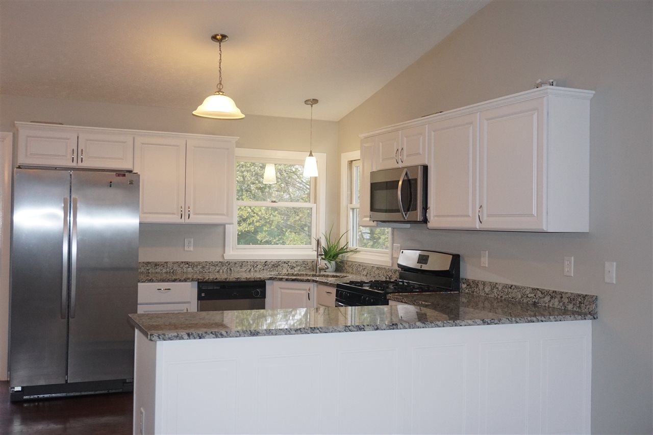 403 Pembroke Road Southwest Poplar Grove, IL 61065 - Photo 4 of 19 a kitchen with granite countertop a sink a counter top space cabinets and stainless steel appliances