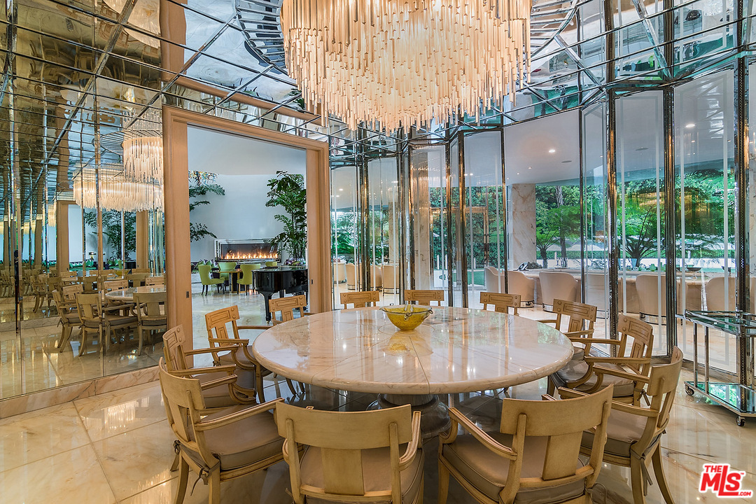 1000 Elden Way Beverly Hills, CA 90210 - Photo 12 of 53 a dining table and chairs with the view of the glass windows