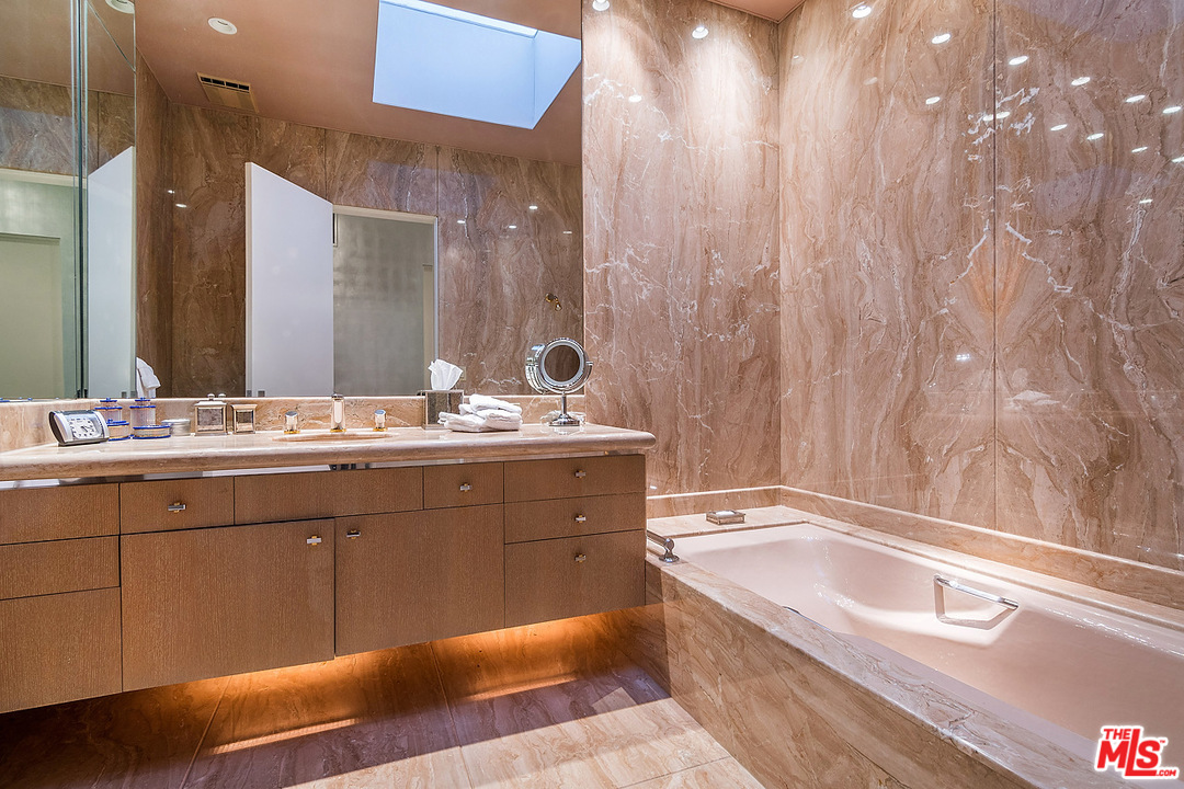 1000 Elden Way Beverly Hills, CA 90210 - Photo 28 of 53 a bathroom with a bathtub sink and mirror