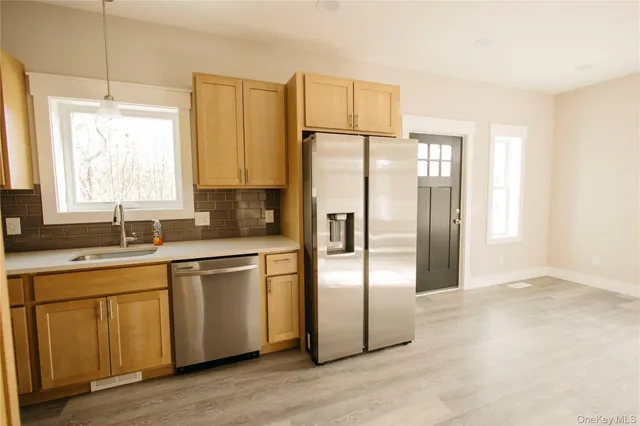 a kitchen with stainless steel appliances a refrigerator sink and cabinets