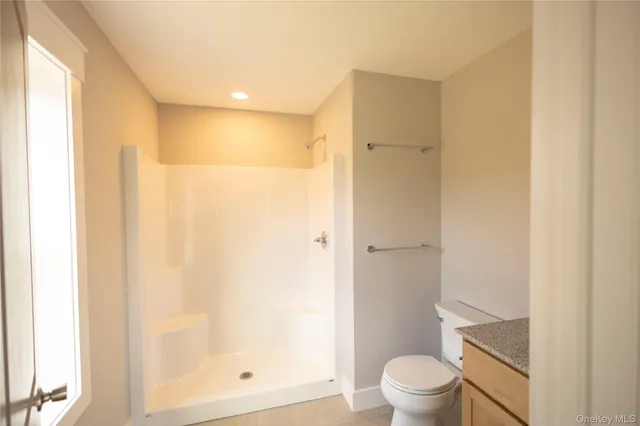 a bathroom with a granite countertop sink toilet and shower