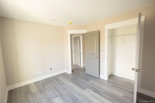 an empty room with wooden floor and window